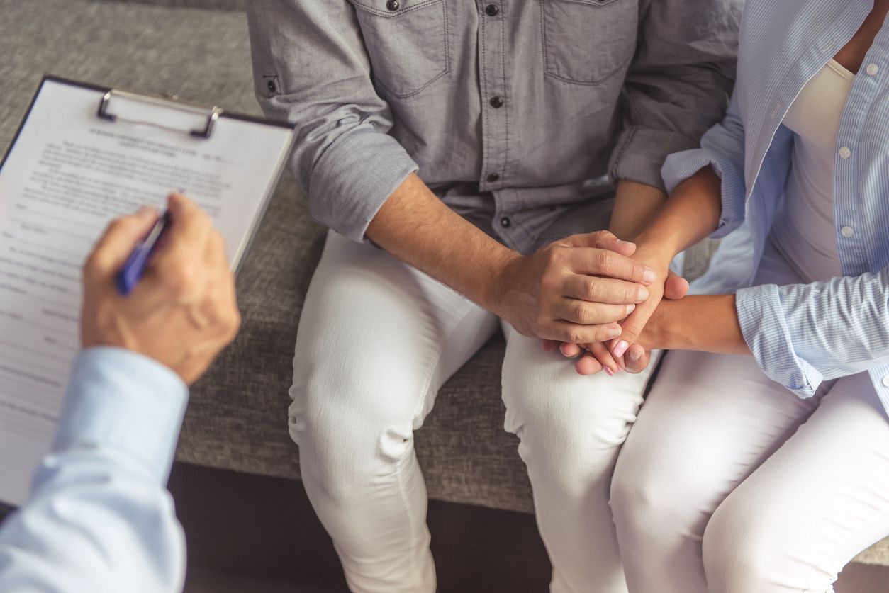 Therapist taking notes while meeting with a couple